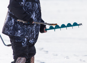 Man catches fish on ice in winter