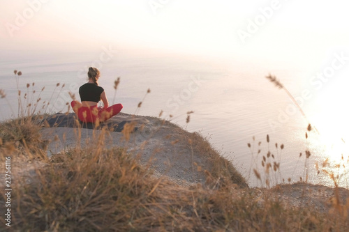 Fotografía Beautiful view of woman doing yoga on the mountain with sea view at sunset