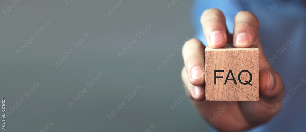 Man holding FAQ message on wooden cube. Frequently Asked Questions - obrazy, fototapety, plakaty 