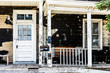Old abandoned weathered wooden house with porch entrance, peeling paint, dirty windows