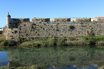 ancient fortification in the city of Peniche in Portugal lined with water and its reflections