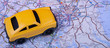 © Evgenia Parajanian - Yellow toy car on map surface (Washington, DC, USA). Road trip or rent car concept. Wide photo.
