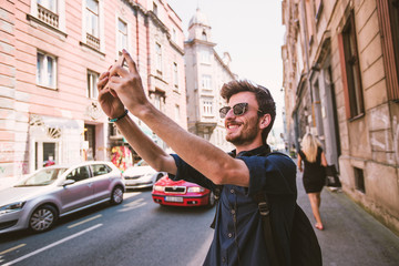 Wall Mural - Tourist man taking selfie with smartphone