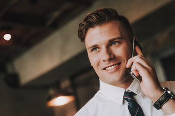 Wall Mural - Concept of success and confidence. Close up portrait of smiling business male talking by phone. Copy space on left