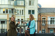© Богдан Перфильев - Two friends young beautiful women are sitting in cafe on the terrace on the roof  in old city centre and drinking cocktails, smiling