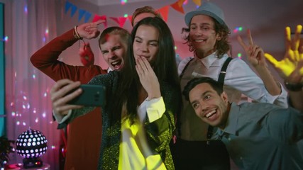 Wall Mural - Happy Group of Young People Taking Collective Selfie at the Wild House Party. Neon Lights, Disco Ball and Funny Costumes.