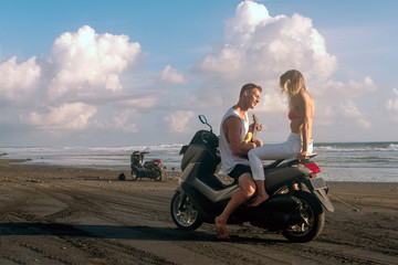 Wall Mural - A man and a woman on a motorcycle. Hawaii, black sand beach