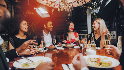 Group of Happy Friends Meeting and Having Dinner