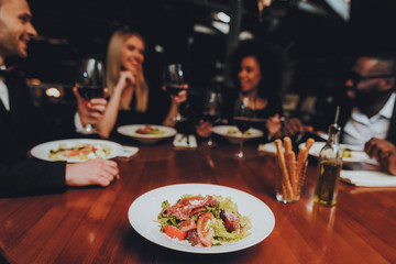 Group of Happy Friends Meeting and Having Dinner