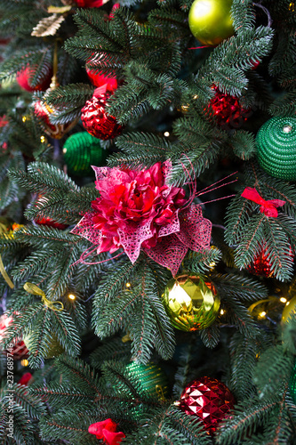 Green Christmas tree decorated with Christmas gifts and a garland. New Year. © vfhnb12