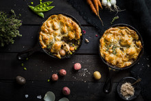 Pair Of Chicken Pot Pies Baked In Cast Iron Skillets On Dark Background
