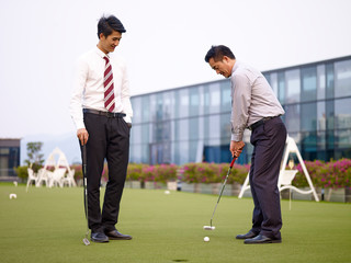 Wall Mural - asian corporate executives playing golf on rooftop court