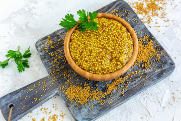 Wall Mural - Bowl with grain mustard and yellow mustard seeds.