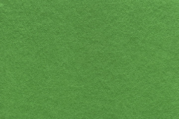 Texture of old dark green paper background, closeup. Structure of dense moss cardboard