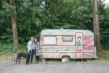 Couple Walking Dog Standing By Caravan