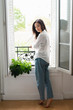 © Westend61 - Portrait of attractive young woman standing at the window