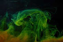 Black Background With Abstract Green And Orange Swirls Of Paint
