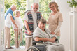Group of positive senor friends with their caregiver in nursing home for elderly