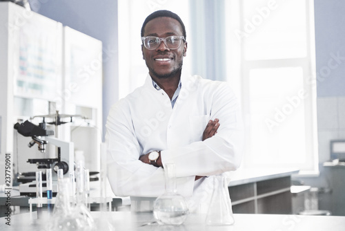 Fotomural The scientist works with a microscope in a laboratory conducting experiments and formulas