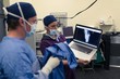 © Wavebreak Media - Female nurse showing x-ray report to male surgeon on laptop