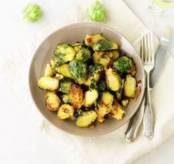 Brussels sprouts roasted fried with onions on a plate top view. Vegetable vegetarian food.