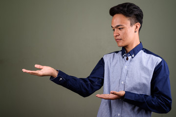 Young handsome Indian man looking smart against colored backgrou