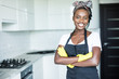© F8  \ Suport Ukraine - Smiling african american housewife in apron with arms crossed cleaning at home