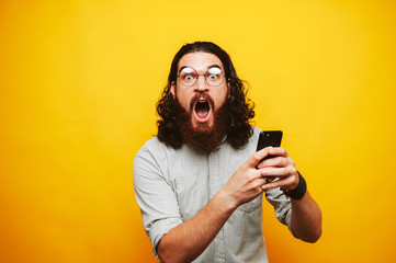 Photo of amazed bearded hioster man in shirt with glasses