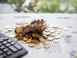 Wall Mural - light bulb with coin on business graph. the idea of ​​reducing costs and reduce energy consumption a