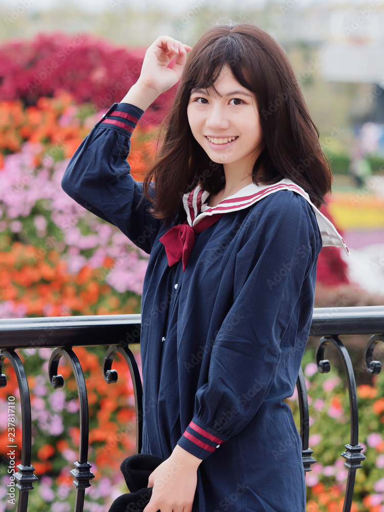 Outdoor portrait of beautiful young Chinese girl in blue school uniform ...