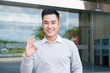 © makistock - Handsome asian man  showing ok hand sign outdoors