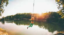 A Woman Is Riding A Swing.