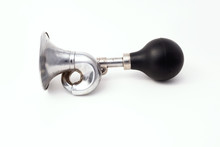 A Worn Iron Horn Or Klaxon From A Vintage Car Or Bicycle Lies Horizontally. Isolated On A Light Background With A Shadow.