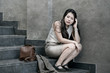 © TheVisualsYouNeed - depressed and desperate Asian Chinese businesswoman crying alone sitting on street staircase suffering stress and depression crisis being victim of mobbing or fired