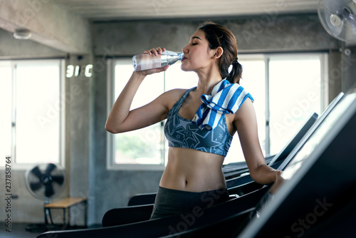 Fotografía asian women thirsty drinking water after exercise in fitness gym