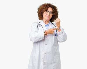 Sticker - Middle ager senior doctor woman over isolated background In hurry pointing to watch time, impatience, upset and angry for deadline delay