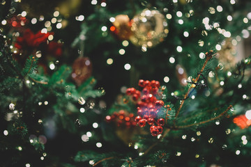 Decorated Christmas tree closeup. Golden balls and illuminated garland with flashlights. New Year baubles macro photo with bokeh. Winter holiday light decoration