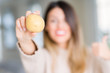 © Krakenimages.com - Young beautiful woman holding fresh potato at home pointing and showing with thumb up to the side with happy face smiling