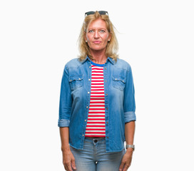 Sticker - Middle age blonde woman over isolated background with serious expression on face. Simple and natural looking at the camera.