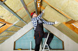© artursfoto - Man installing thermal roof insulation layer - using mineral wool panels. Attic renovation and insulation concept