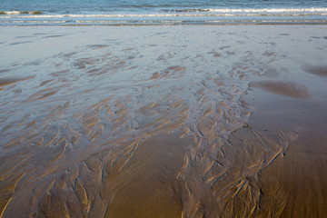 waves draw pattern on the beach