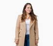 © Krakenimages.com - Beautiful plus size young woman wearing winter coat over isolated background smiling looking side and staring away thinking.