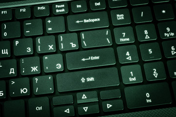 Poster - Electronic collection - laptop keyboard. The focus on the Enter key. Toning is green.