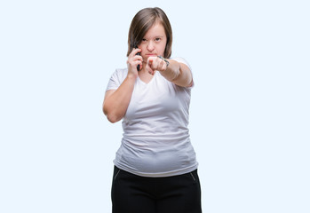 Sticker - Young adult woman with down syndrome taking using smartphone over isolated background pointing with finger to the camera and to you, hand sign, positive and confident gesture from the front