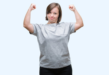 Sticker - Young adult woman with down syndrome over isolated background showing arms muscles smiling proud. Fitness concept.