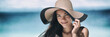 © Maridav - Beach sun tan skin care Asian beauty woman happy on beach vacation panoramic banner wearing sunhat. Healthy suntan skincare concept with hat.
