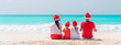 © travnikovstudio - Happy family on the caribbean beach celebrating Christmas vacation