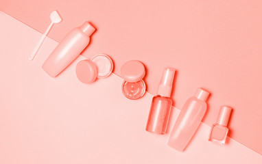 Living Coral colored Decorative cosmetic and creams set on pink background. Minimalism cosmetics style. Top view, flat lay. Creative fashion beauty concept of color of the year 2019. 16-1546