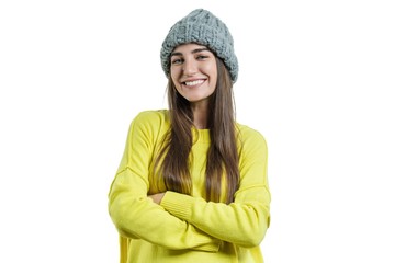 Wall Mural - Young beautiful woman in yellow sweater and gray big loop knitted beanie hat, hands folded, looking at the camera on white isolated background