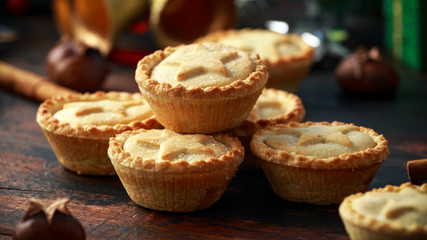 British Christmas mince pies with decoration, gifts, green tree branch on wooden rustic table